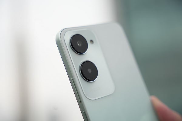 A hand holding a phone with camera lens
Description automatically generated